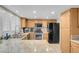 Bright kitchen with stainless appliances, granite counters, and light wood cabinets and large window at 37 Stone Cress Dr, Henderson, NV 89074