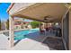 Spacious covered patio featuring outdoor seating, ceiling fans, and a built-in grill overlooking the pool area at 37 Stone Cress Dr, Henderson, NV 89074