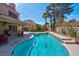 Enjoy a refreshing dip in the sparkling pool, complemented by a covered patio and lush green landscaping at 37 Stone Cress Dr, Henderson, NV 89074