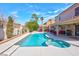 Sparkling pool and spa with covered patio, surrounded by palm trees, creating a serene backyard retreat at 37 Stone Cress Dr, Henderson, NV 89074