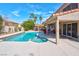 Enjoy a refreshing swim in this pristine pool and unwind in the adjacent covered patio and lush backyard at 37 Stone Cress Dr, Henderson, NV 89074