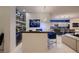 Open-concept bar area flowing into the kitchen and living room with blue chairs and sleek design at 4087 Villa Rafael Dr, Las Vegas, NV 89141