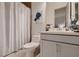 Well-lit bathroom featuring a toilet, sink with white cabinet, shower with curtain, and decor at 4087 Villa Rafael Dr, Las Vegas, NV 89141