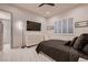 Comfortable bedroom featuring a queen bed, a wall-mounted TV, white shutters, and marble tile flooring at 4087 Villa Rafael Dr, Las Vegas, NV 89141