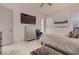 Modern bedroom featuring a large TV, dresser, stylish decor, and elegant marble flooring at 4087 Villa Rafael Dr, Las Vegas, NV 89141
