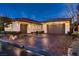 Charming single-story home with a well-manicured yard and a two-car garage at dusk at 4087 Villa Rafael Dr, Las Vegas, NV 89141