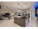 Bright living room features a piano, modern lighting, and a large kitchen island at 4087 Villa Rafael Dr, Las Vegas, NV 89141