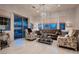 Well-lit living room with a brown velvet couch and patterned armchairs by large window at 4087 Villa Rafael Dr, Las Vegas, NV 89141