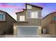Two-story home with a two-car garage and neutral colored stucco exterior at 4371 Fire Glow Ave, North Las Vegas, NV 89084