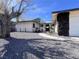 Stylish front exterior showcasing desert landscaping, mature trees, and a unique rock wall feature at 4485 Greenhill Dr, Las Vegas, NV 89121
