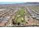 An aerial view of a sprawling desert community featuring a golf course, ponds, and tile roofed homes at 4963 Pensier St, Las Vegas, NV 89135
