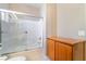 Bathroom with bath tub and glass sliding doors and wood cabinet for storage at 4963 Pensier St, Las Vegas, NV 89135