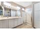 Bathroom featuring dual sinks, vanity cabinets, and a glass-enclosed shower at 4963 Pensier St, Las Vegas, NV 89135