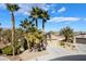Stylish single-story home with desert landscaping, mature palm trees, a spacious driveway, and a two-car garage at 4963 Pensier St, Las Vegas, NV 89135
