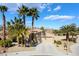 Attractive single-story home featuring desert landscaping and palm trees, a wide driveway, and a two-car garage at 4963 Pensier St, Las Vegas, NV 89135