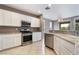 Bright kitchen with stainless steel appliances, white cabinetry and tile floors at 4963 Pensier St, Las Vegas, NV 89135