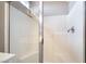 Shower featuring white tiled walls and shower head inside glass door enclosure at 4963 Pensier St, Las Vegas, NV 89135