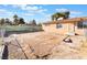 Rear view of charming home with chain-link fence and desert landscaping, presenting an opportunity for customization at 4970 E Van Buren Ave, Las Vegas, NV 89110
