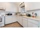 Classic kitchen with white cabinetry, neutral countertops, and essential appliances for a functional cooking space at 4970 E Van Buren Ave, Las Vegas, NV 89110