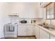 Well-maintained kitchen with white appliances and cabinetry, offering a clean and efficient cooking area at 4970 E Van Buren Ave, Las Vegas, NV 89110