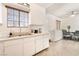 Bright kitchen features a sink with a view, white cabinetry, and a seamless flow to the dining area at 4970 E Van Buren Ave, Las Vegas, NV 89110