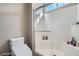 Bright white tiled shower features a glass door, toilet with bidet feature, and shower niche at 524 Teovani St # 826, Henderson, NV 89052