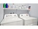 Well-equipped laundry area with new, white washer and dryer units and storage at 528 Thistleberry Ave, Henderson, NV 89044