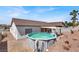 Backyard showcasing an above-ground pool, covered patio, desert landscaping, and mature palms at 531 Coolidge Ave, Henderson, NV 89015
