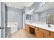 Bathroom featuring dual sinks, vanity and walk-in shower with a large tub at 531 Coolidge Ave, Henderson, NV 89015