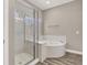 Bathroom with walk-in shower, soaking tub, and wood-look flooring at 531 Coolidge Ave, Henderson, NV 89015