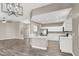 Open-concept living space with modern lighting fixtures, white kitchen, and wood-look floors at 531 Coolidge Ave, Henderson, NV 89015
