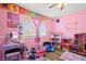 Adorable pink bedroom featuring a decorative window and laminated floors at 5717 Christchurch Ave, Las Vegas, NV 89110