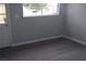 Empty bedroom with gray carpet, a window, and a door leading outside at 6225 Factor Ave, Las Vegas, NV 89107
