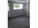 Empty bedroom with gray carpet and door leading to outdoor space at 6225 Factor Ave, Las Vegas, NV 89107
