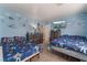 Brightly decorated bedroom with twin beds and blue toy-themed wallpaper, plus TV at 6552 Casamar St, North Las Vegas, NV 89086