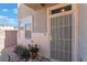 Close-up of a home's front door, showcasing a secure screen door and decorative potted plants at 6552 Casamar St, North Las Vegas, NV 89086