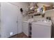 Well-organized laundry room with washer, dryer, shelving, storage baskets, and a door with a pet entrance at 6552 Casamar St, North Las Vegas, NV 89086