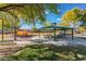 Community park featuring a gazebo with picnic tables, a playground, mature trees, and park benches at 6552 Casamar St, North Las Vegas, NV 89086