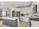 Modern kitchen featuring white cabinets, quartz countertops, stainless steel appliances, a kitchen island, and light-colored wood floors at 7122 Red Gulch St, North Las Vegas, NV 89084