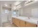 Bright bathroom featuring dual sinks, a large mirror, and a shower with glass enclosure at 7228 Buglehorn St, Las Vegas, NV 89131