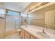 Bright bathroom boasts a double sink vanity, ample lighting, and a glass-enclosed shower at 7772 Buckwood Ct, Las Vegas, NV 89149