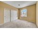 Bedroom with neutral carpet, double sliding door closet and a window at 7772 Buckwood Ct, Las Vegas, NV 89149