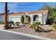 Inviting single-story home with red tile roof, desert landscaping and a two-car garage at 7772 Buckwood Ct, Las Vegas, NV 89149