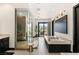 This modern bathroom features a glass shower, a free-standing tub, and access to an outdoor patio at 80 Pristine Glen St, Las Vegas, NV 89135