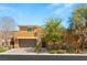 Charming two-story home with a two-car garage, stone accents, and desert landscaping at 80 Pristine Glen St, Las Vegas, NV 89135