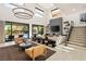 Bright living room with a sleek fireplace, modern chandelier, and staircase to the second floor at 80 Pristine Glen St, Las Vegas, NV 89135