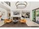 Open living space with bar area, featuring high ceilings, modern chandelier, and access to the gourmet kitchen and outdoor patio at 80 Pristine Glen St, Las Vegas, NV 89135