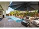 Luxurious swimming pool features a built-in sun shelf and a cozy lounge area with privacy landscaping at 80 Pristine Glen St, Las Vegas, NV 89135