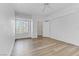 Bright, empty bedroom features wood-look floors, ceiling fan, window, and walk in closet at 8408 Running Deer Ave # 103, Las Vegas, NV 89145