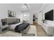 Bright, staged bedroom features wood-look floors, ceiling fan, window, and walk-in closet at 8408 Running Deer Ave # 103, Las Vegas, NV 89145